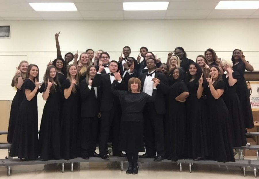 Symphonic choir proudly holding up a one for their achievement earning a one.